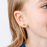 Close-up of hibiscus flower stud earring on a girl