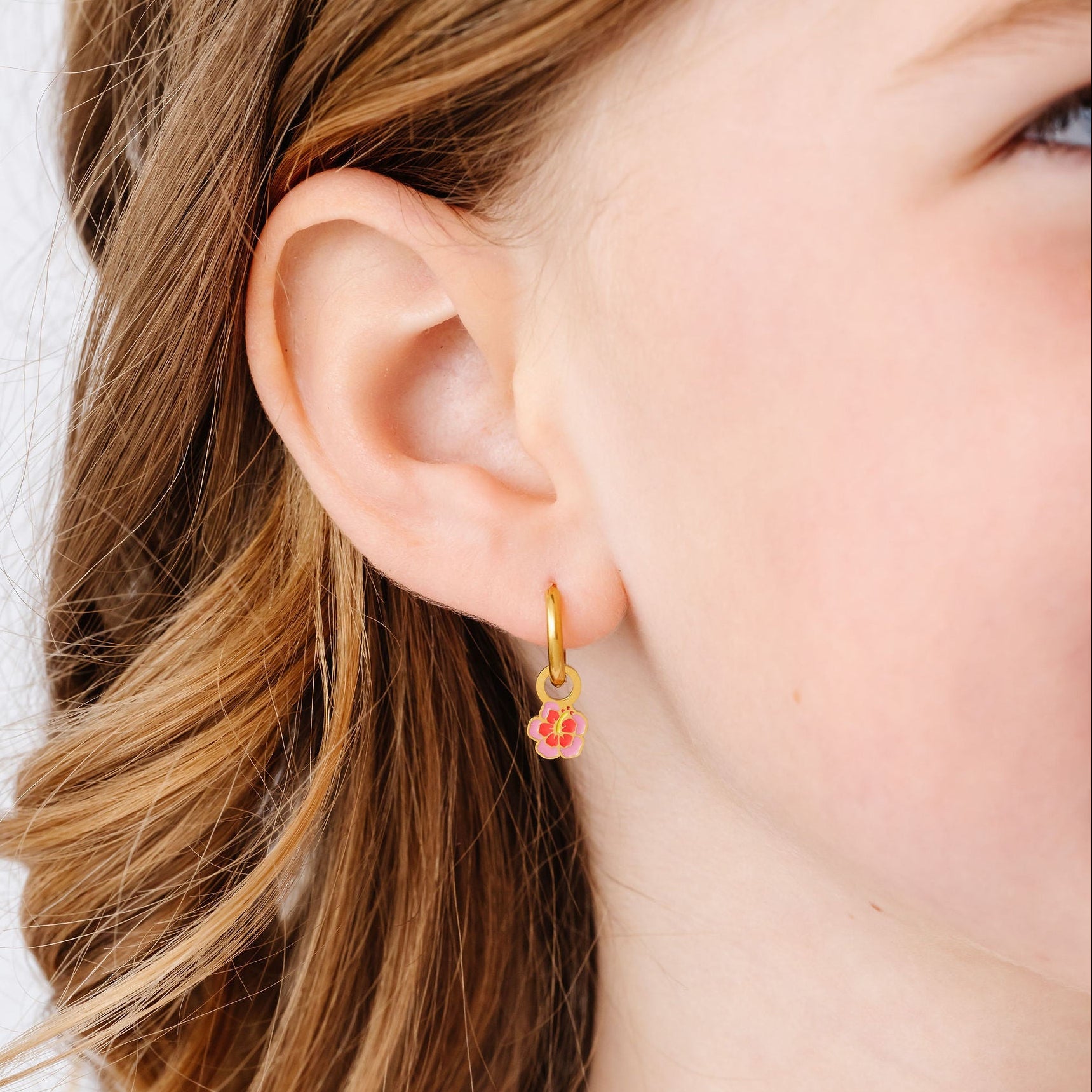 close up of girl wearing a hibiscus flower charm earring