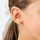close-up of a girl wearing a colorful parrot earring stud