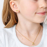 Close-up of a young girl wearing a rainbow earrings with matching rainbow necklace.
