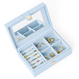 Light blue jewelry box with compartments filled with earrings on a white background