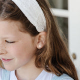 Girl with white headband on wearing a baseball earring stud