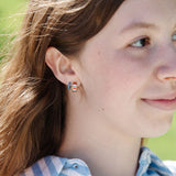 Girl wearing a red white and blue hoop and solid blue hoop