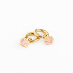 Gold charm with pink seashell earring on a white background