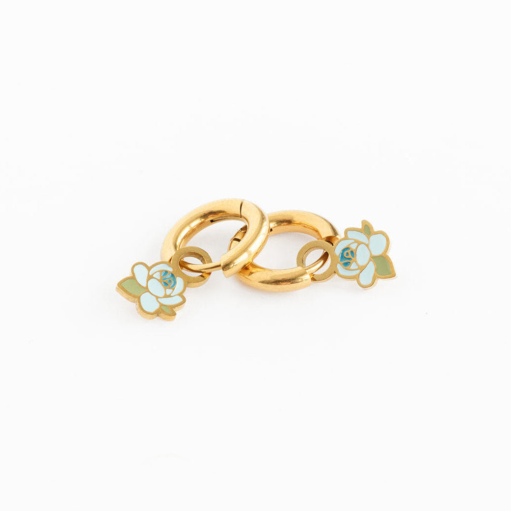 Gold charm with floral designs on a white background