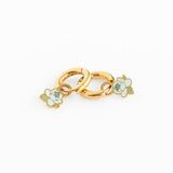 Gold charm with floral designs on a white background
