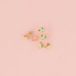 Set of stud earrings on pink background