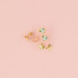 Set of stud earrings on pink background