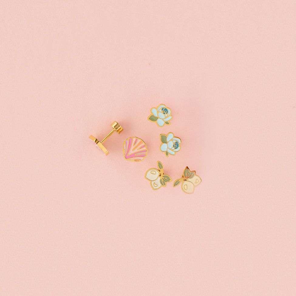 Set of stud earrings on pink background