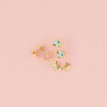 Set of small earrings on a pink background