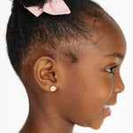 Profile of a girl with a pink seashell earrings on a white background