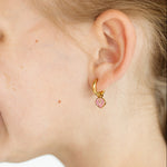 Girl wearing a gold hoop with pink seashell charm