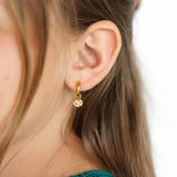 Girl wearing a chocolate chip cookie charm earring 
