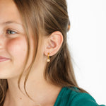 Girl wearing a chocolate chip cookie charm earring 
