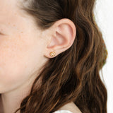 Close-up of a girl wearing a chocolate chip cookie stud earring