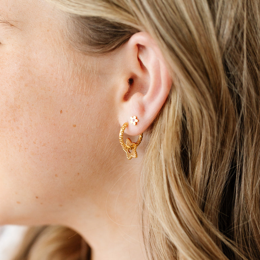 Teen girl wearing Gold Star Braided Hoop earrings and star stud earring