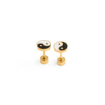 Pair of gold yin yang earrings with black and white designs on a white background